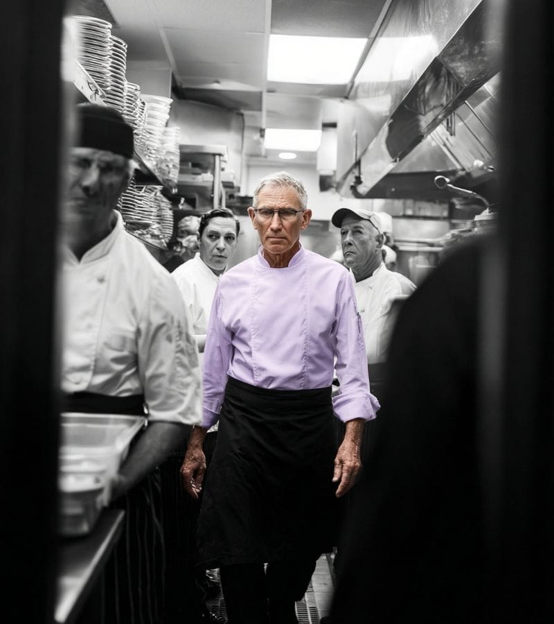 Executive chef plating a dish in a restaurant kitchen